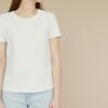 pexels-photo-6786614-6786614 Mockup of a woman in a white t-shirt and jeans on a beige background, ideal for fashion branding.