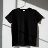 pexels-photo-8532616-8532616 Minimalist image of a black t-shirt on a hanger with dramatic shadows on a white wall.